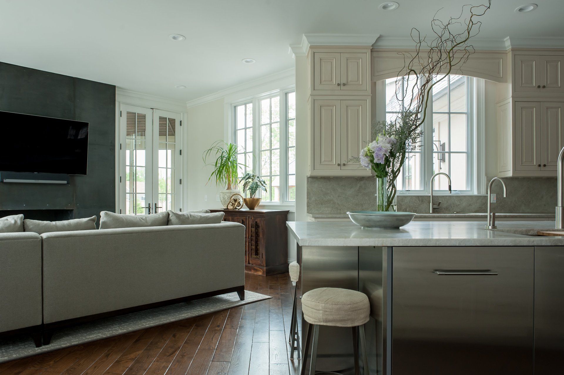 A living room with a couch and a kitchen with a stainless steel island.