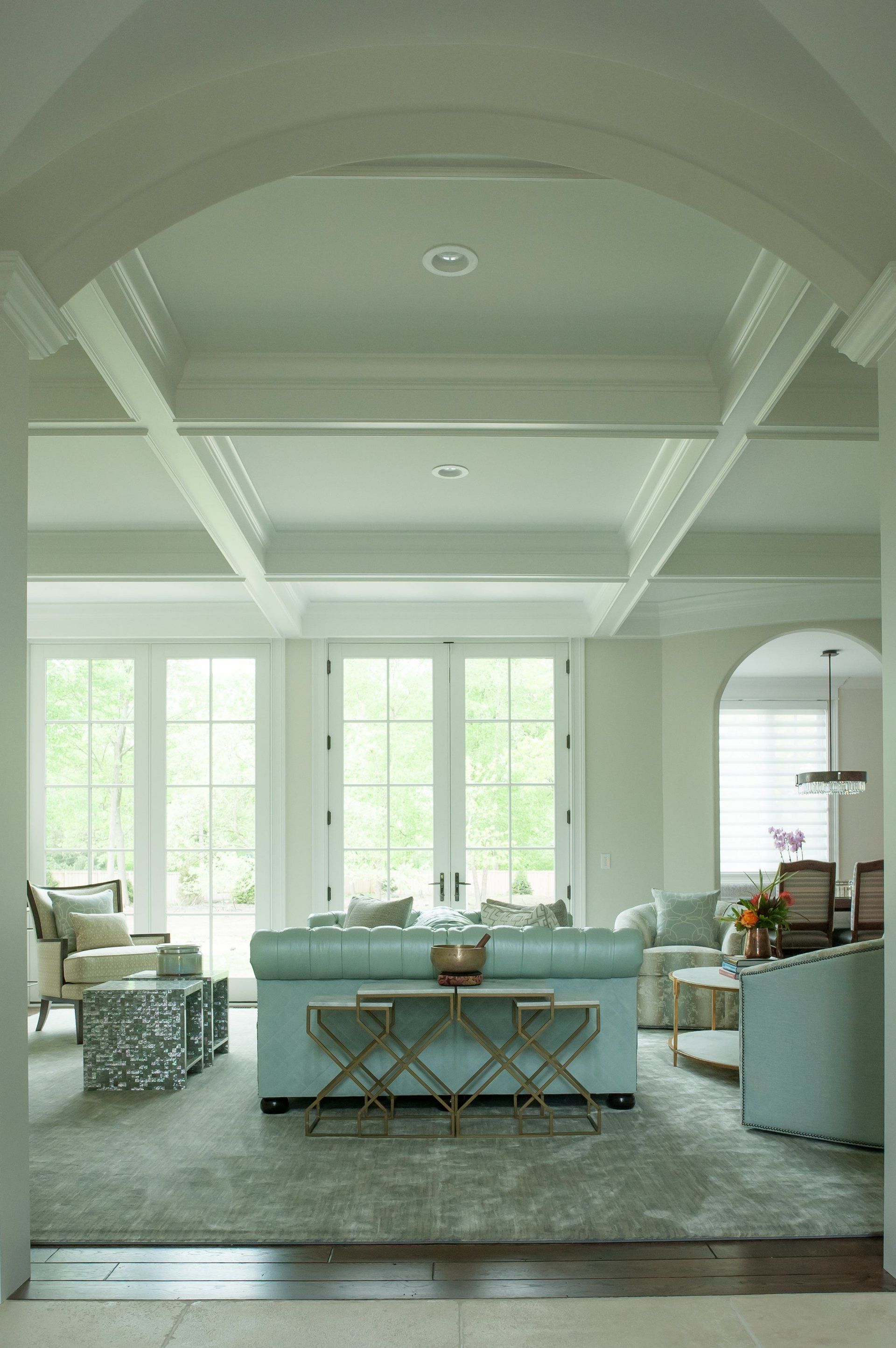 A living room with a blue couch and lots of windows