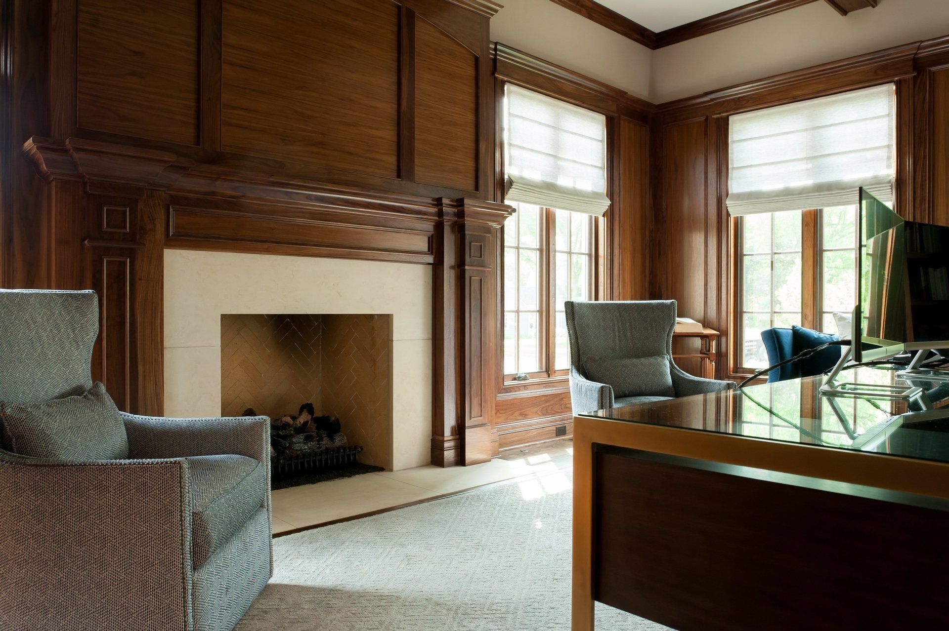 A living room with a fireplace , desk and chairs