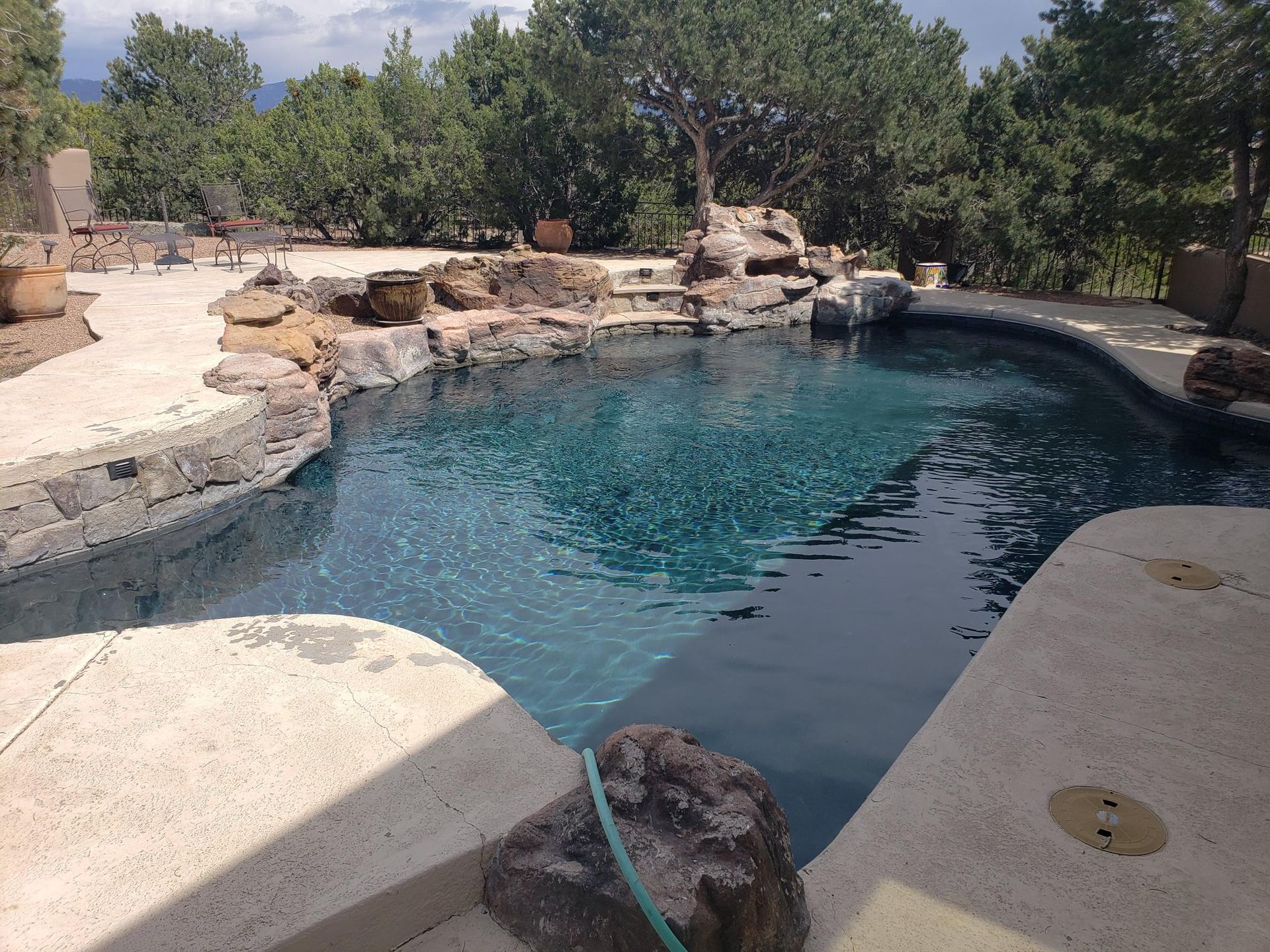 A Large Swimming Pool Surrounded by Rocks and Trees