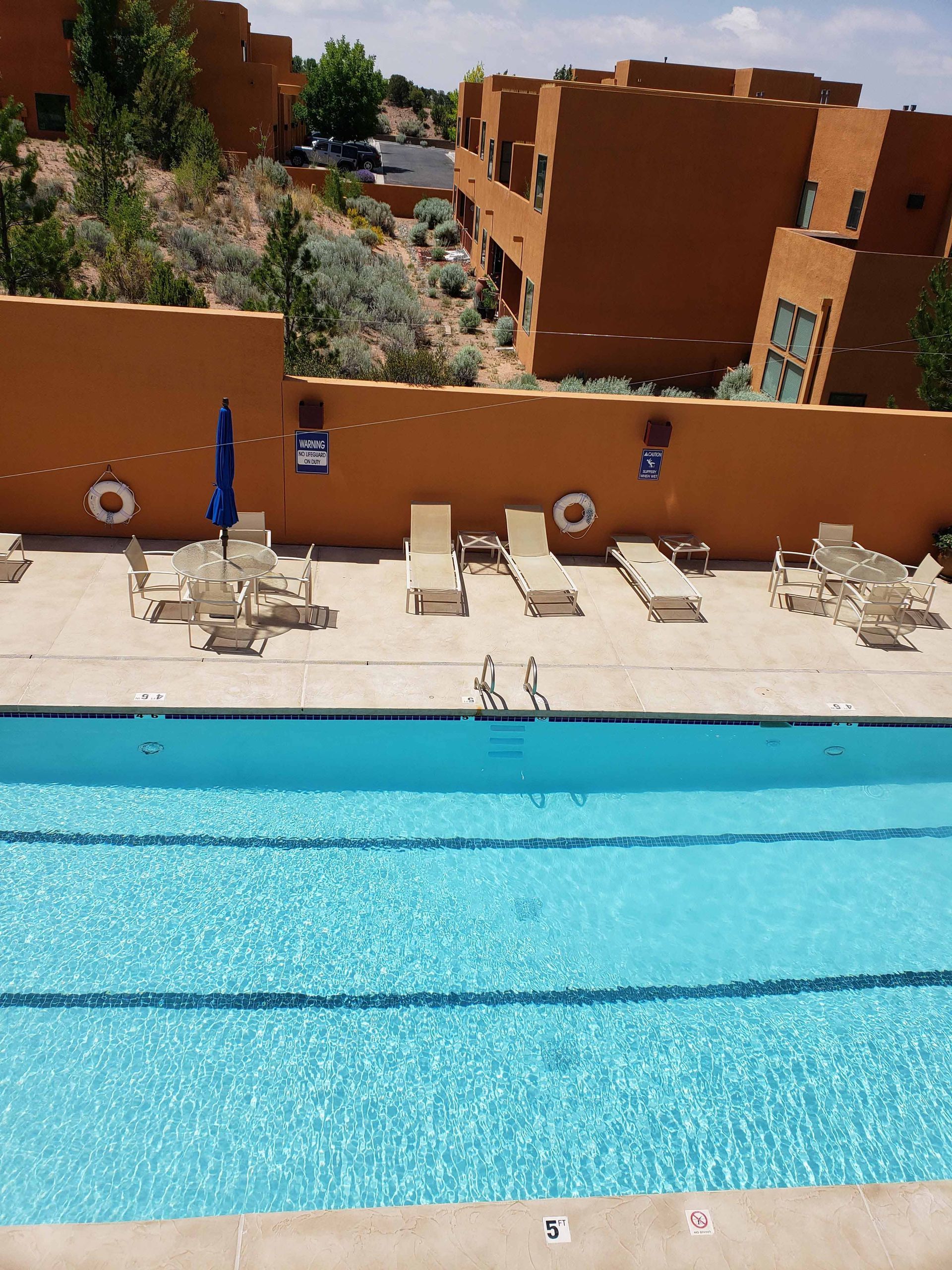 An aerial view of a large swimming pool surrounded by chairs and tables