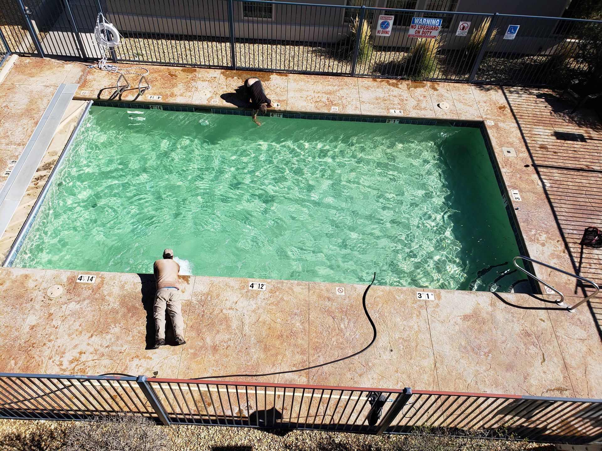 A man is standing on the edge of a swimming pool