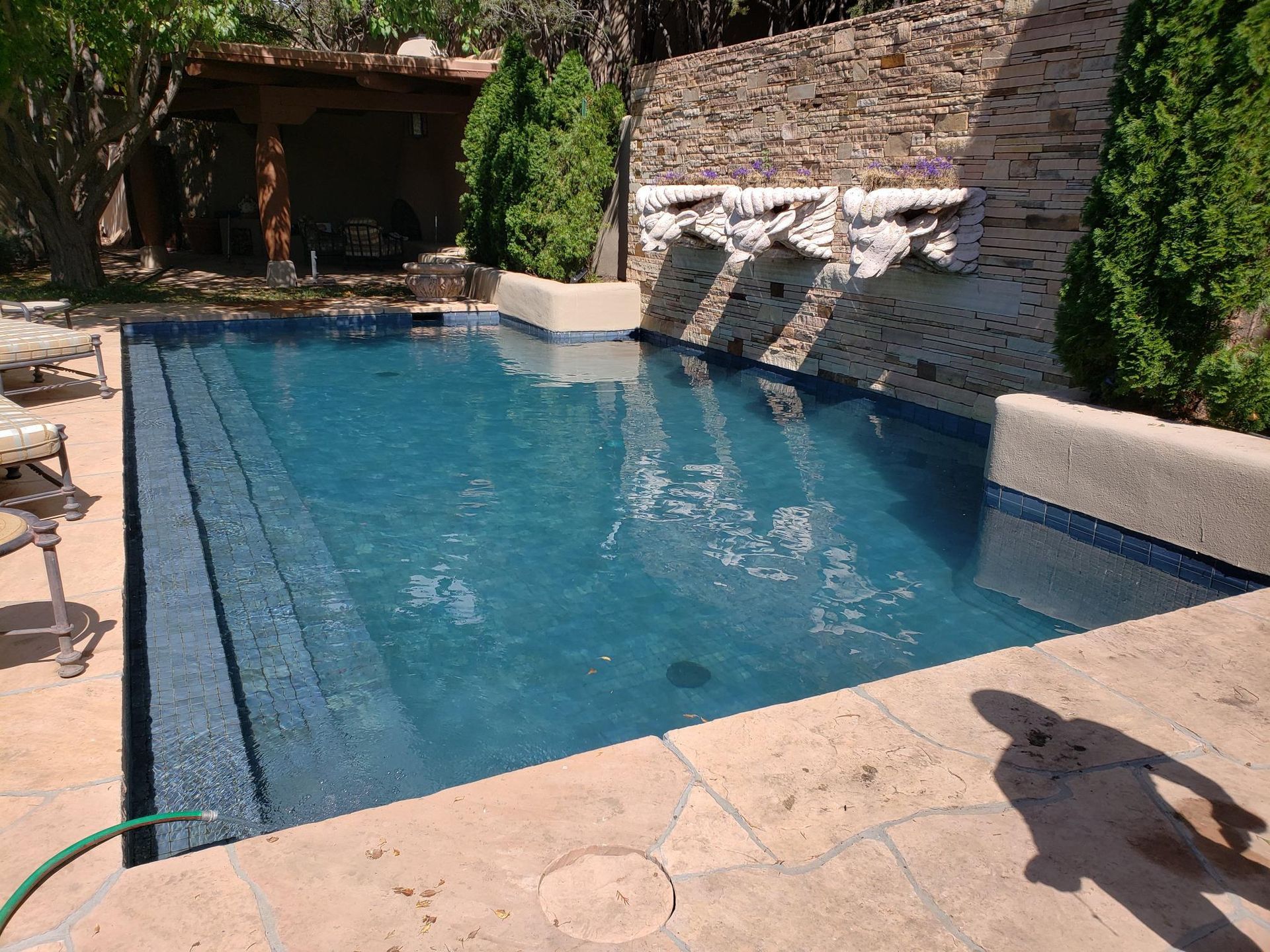 A Large Swimming Pool With a Hose Attached to It
