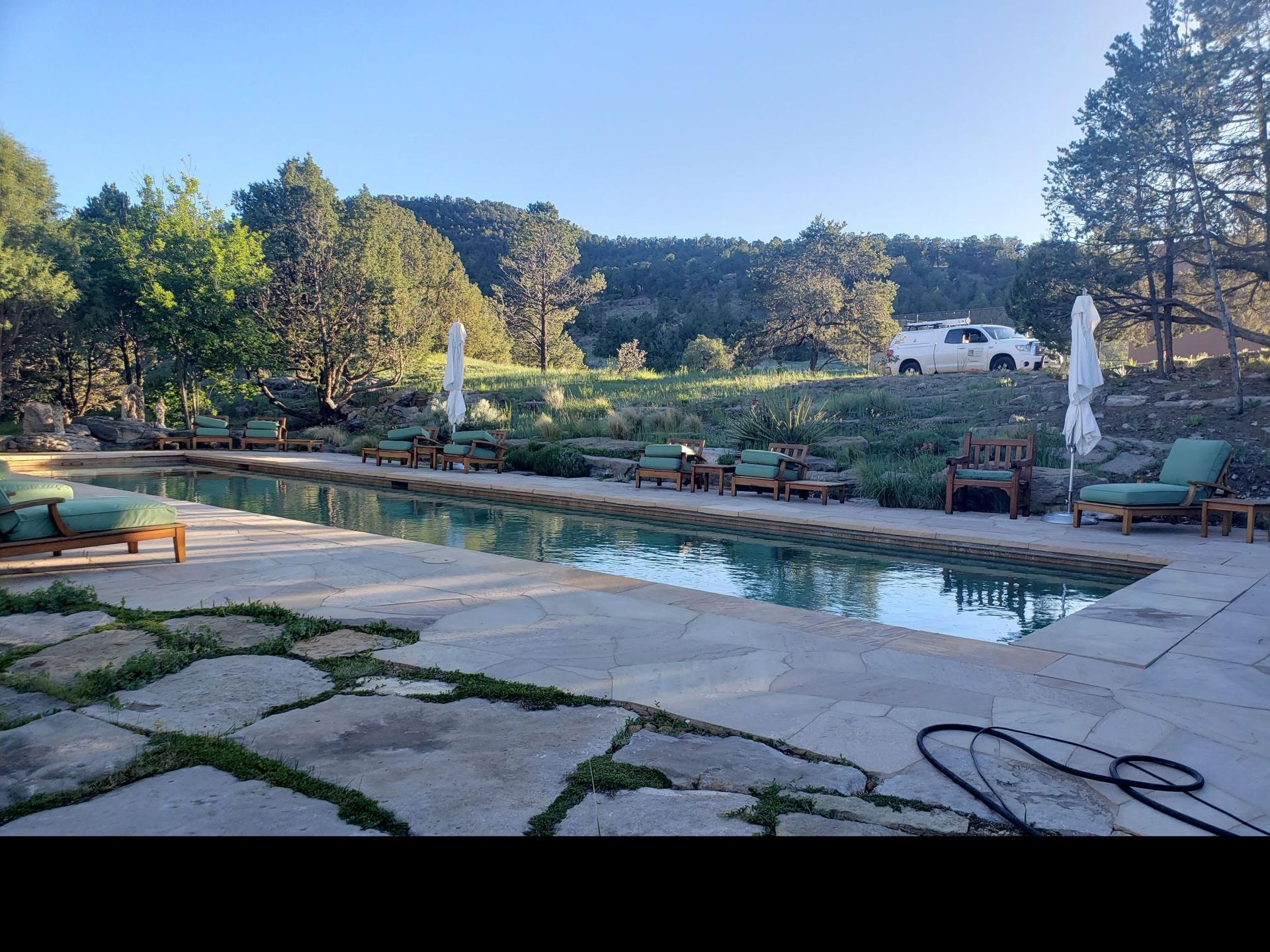 A Large Swimming Pool With Chairs and Umbrellas Around It