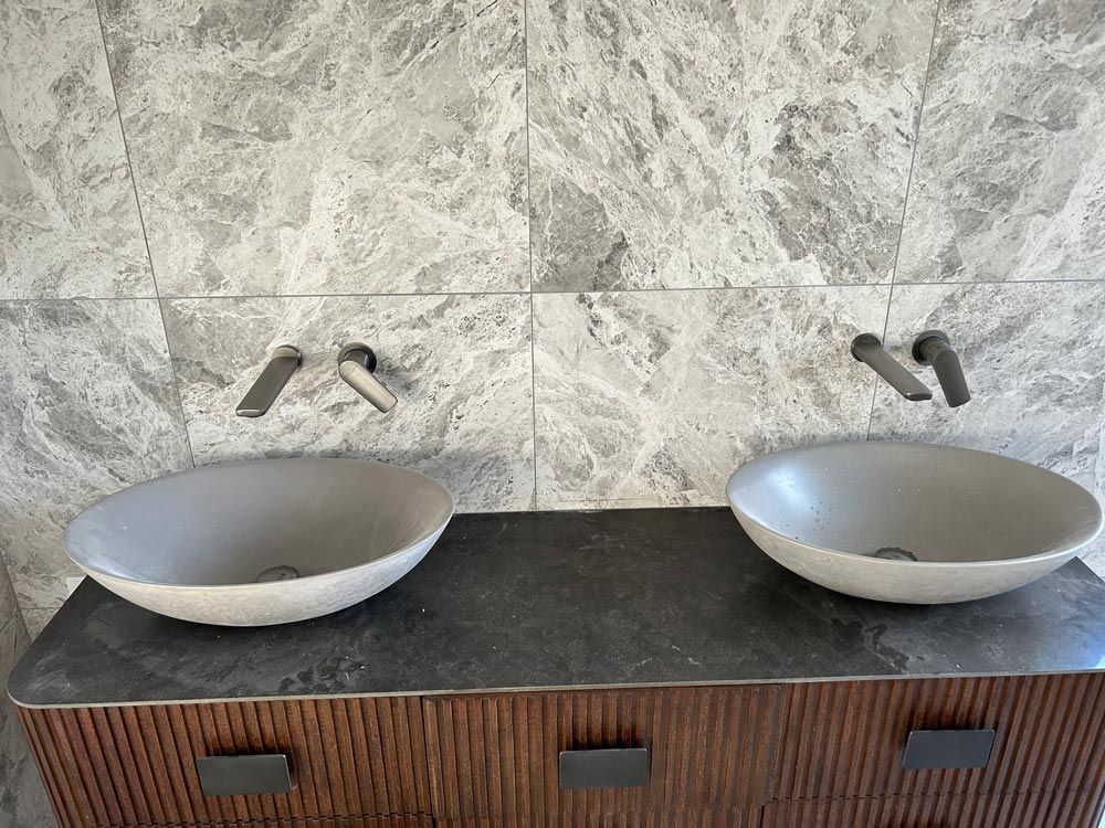 Two Sinks Are Sitting On Top Of A Wooden Vanity In A Bathroom — Professional Plumbing in Mittagong, NSW