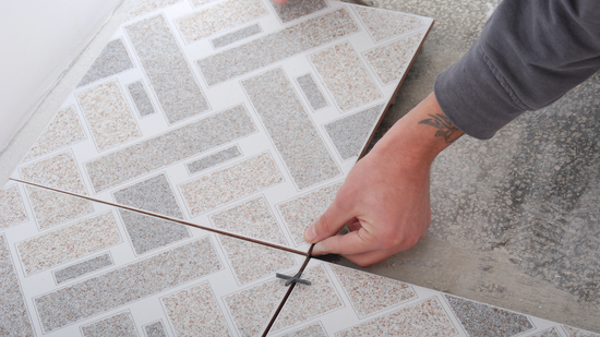 a hand replacing a tile flooring