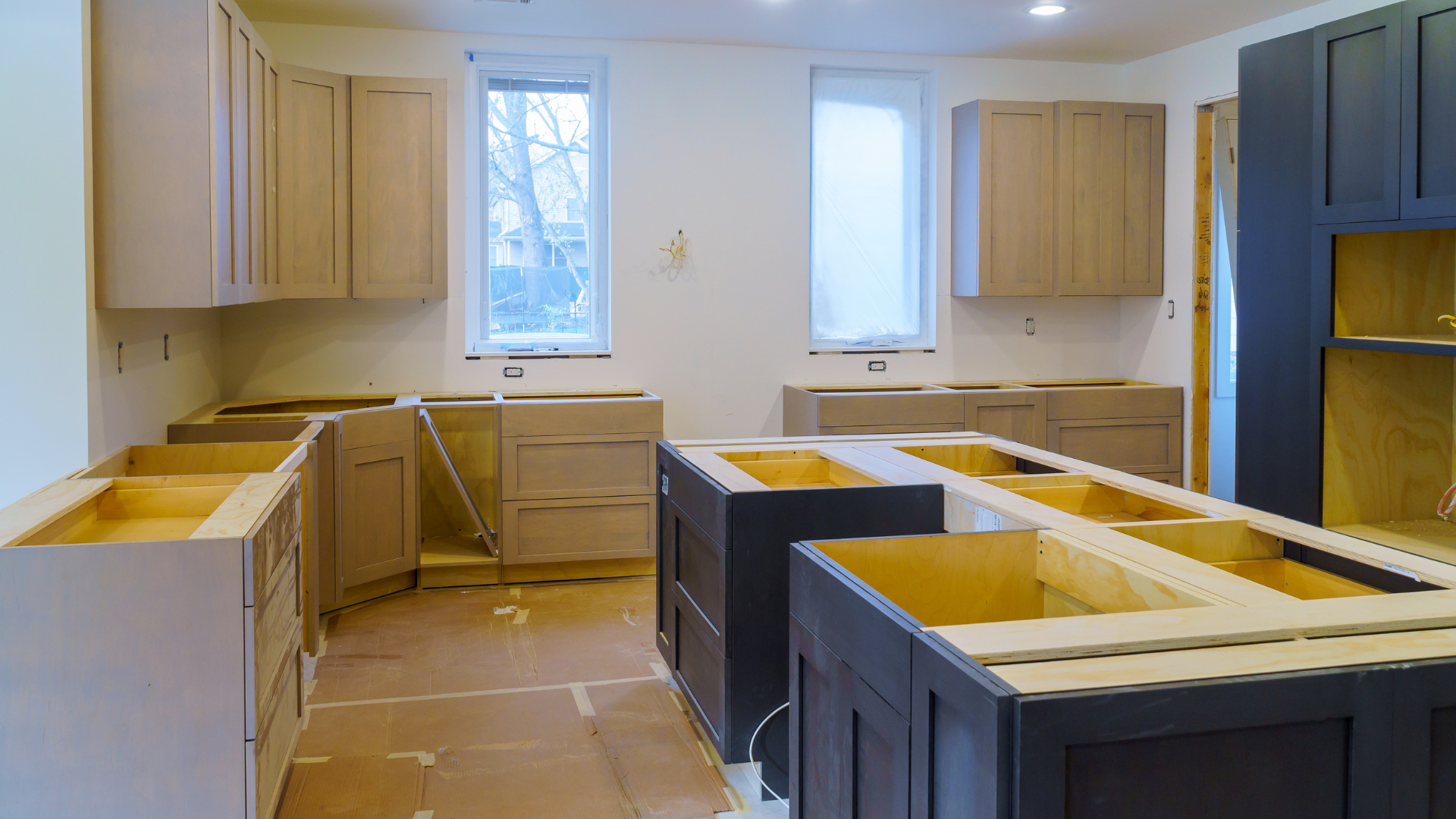 A kitchen under construction with wooden cabinets and a large island.