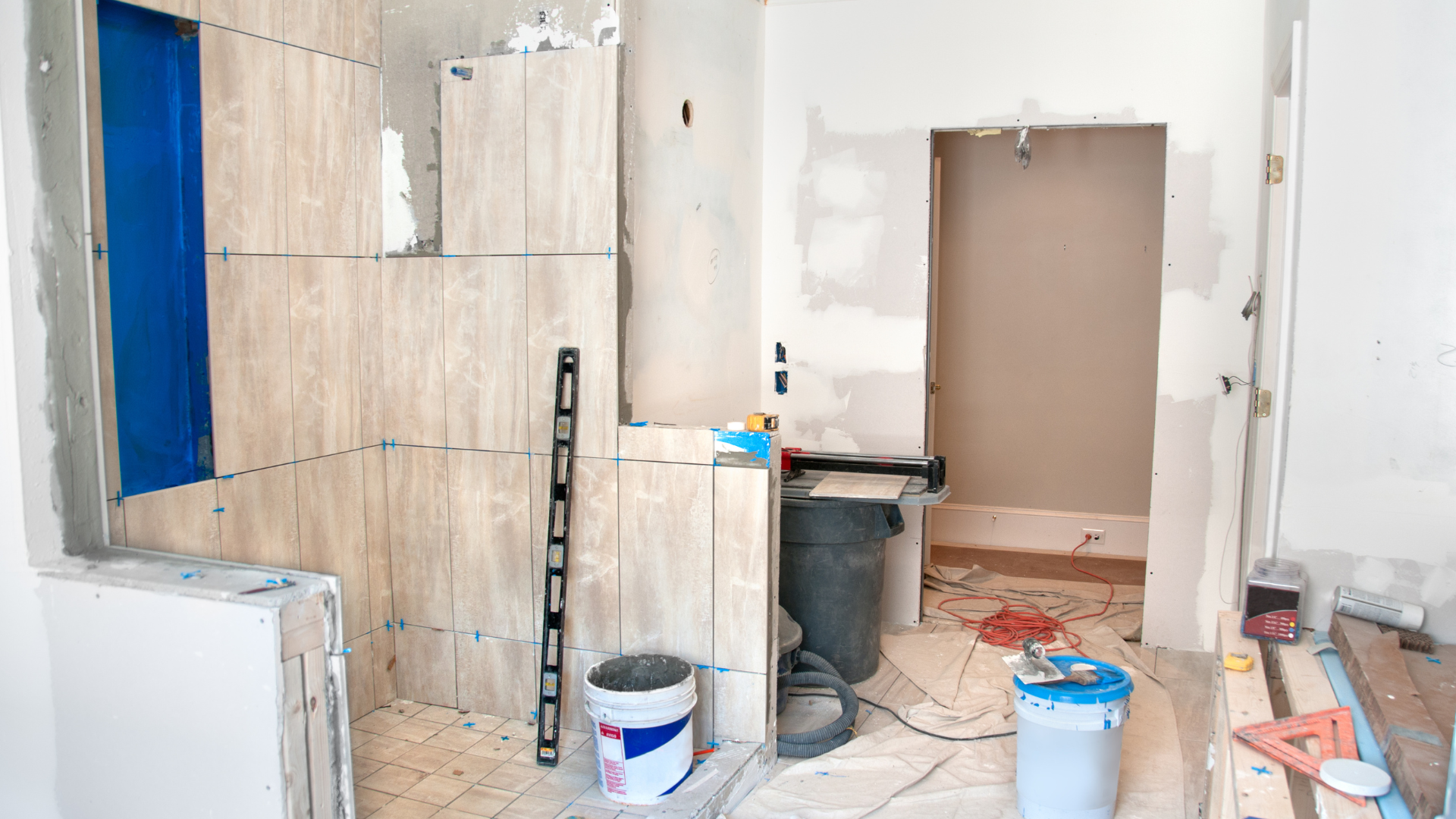 A bathroom is being remodeled with tiles and tools.