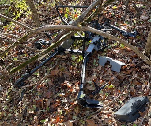 Drone crashed in a tree line.