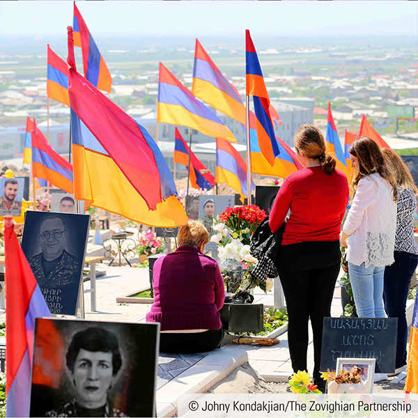 Decorated with flags of Armenia, loved ones grieve the fallen Armenian soldiers, at the Cemetery of Yerablur Military Memorial