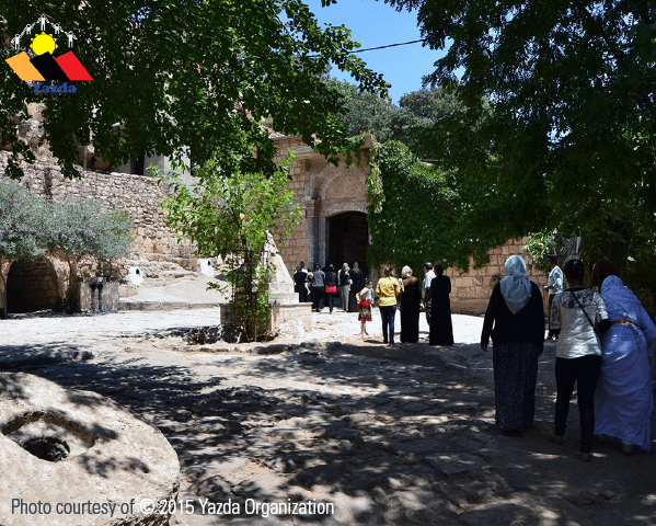 Yazidis stand in a courtyard at the Yazidi Lalish temple