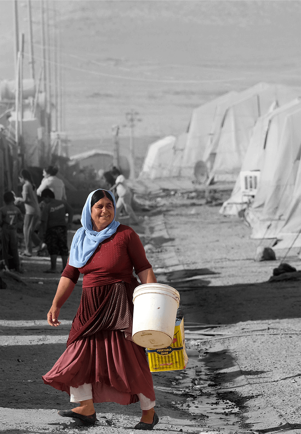 A yazidi woman at the camps with tanks to fill water