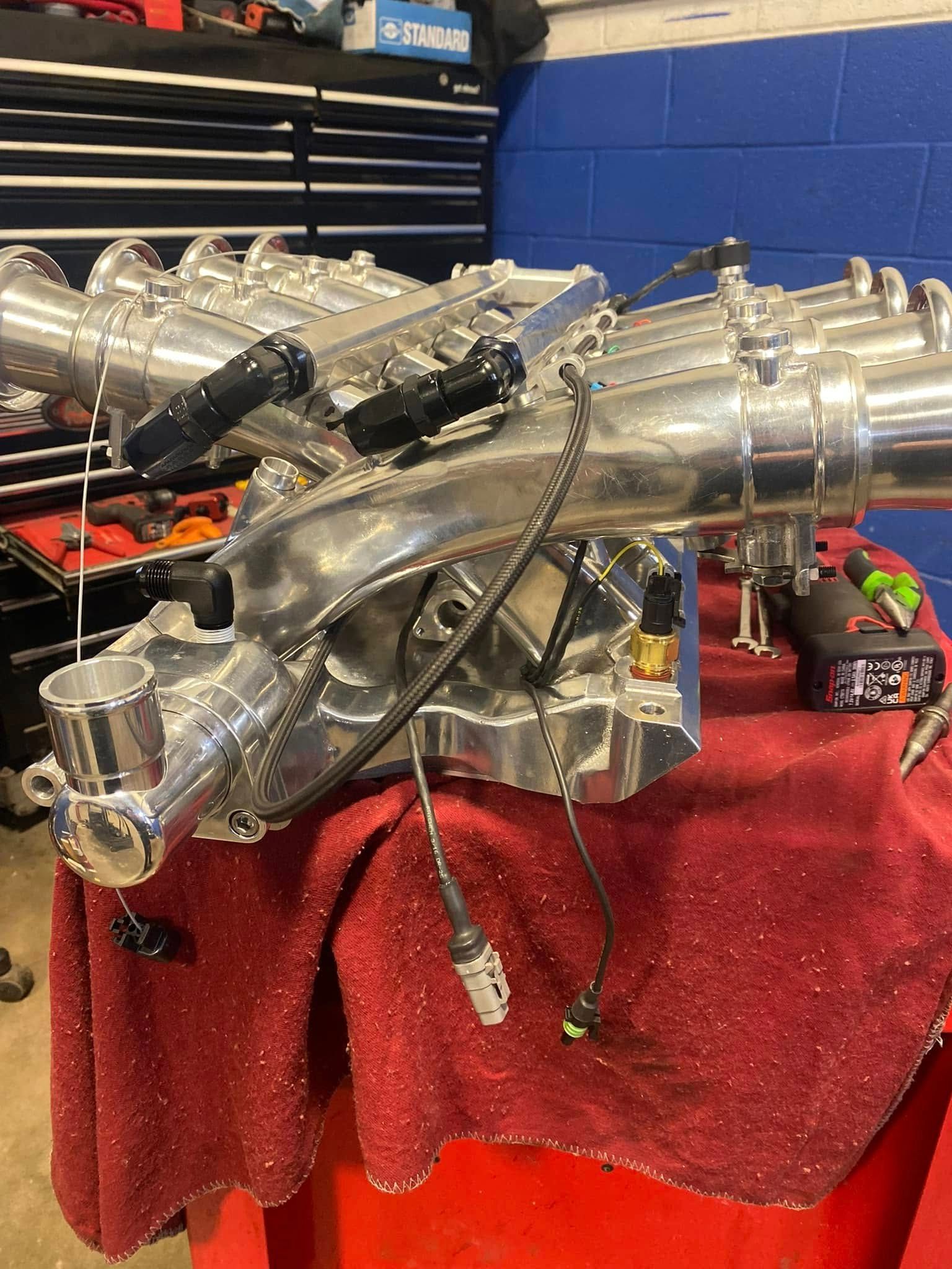 The hood of a car is open and the engine is visible