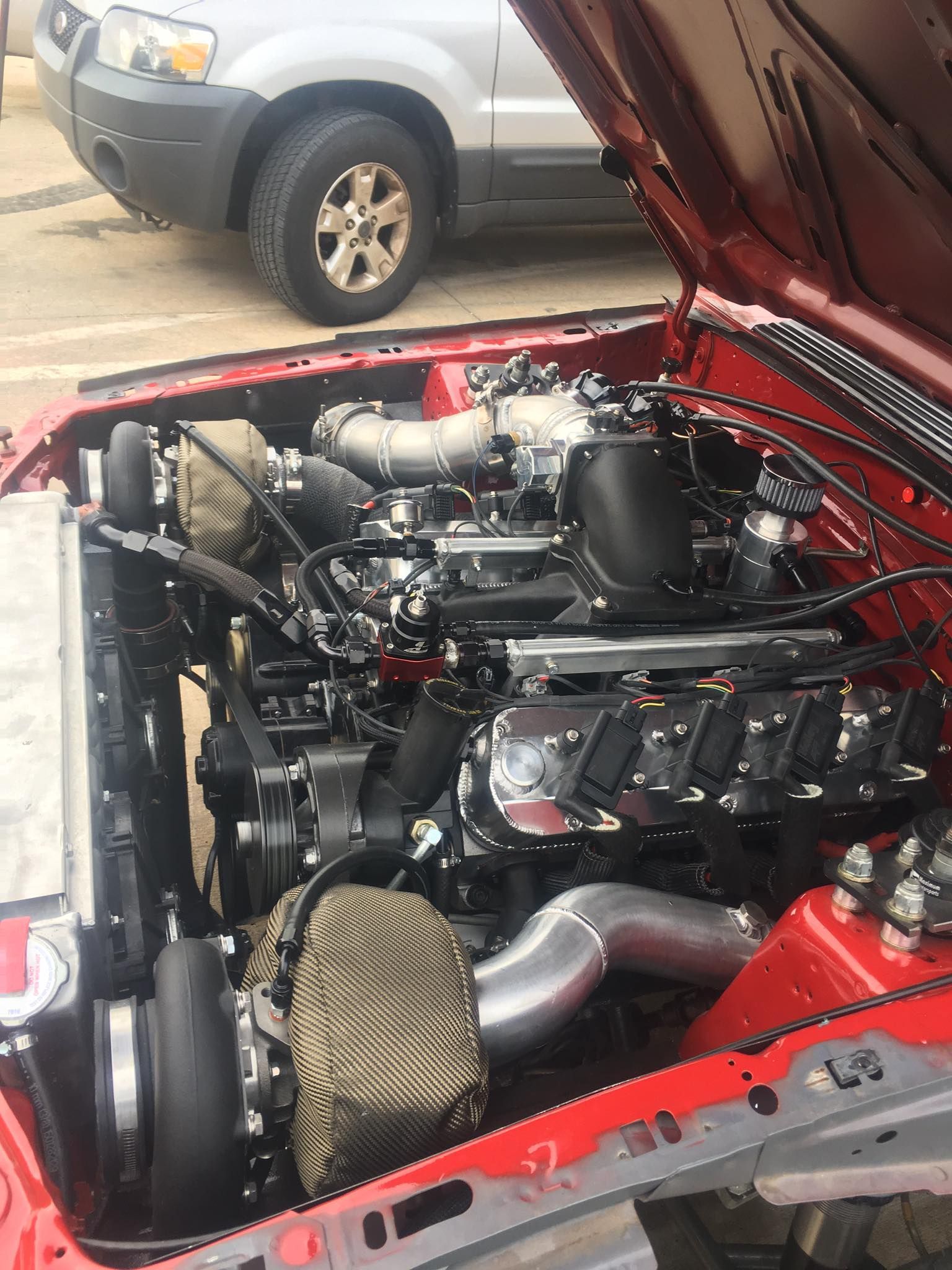 A man is holding a turbocharger on a table.