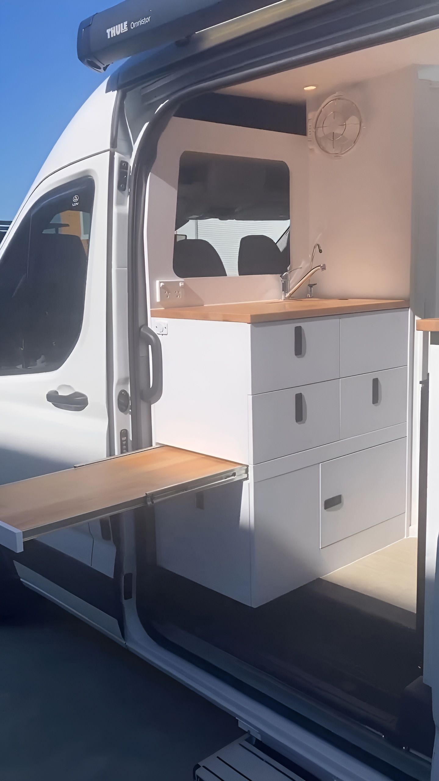 A White Van With A Wooden Table In The Back Of It — Live Unbound Campers In Tweed Heads, NSW