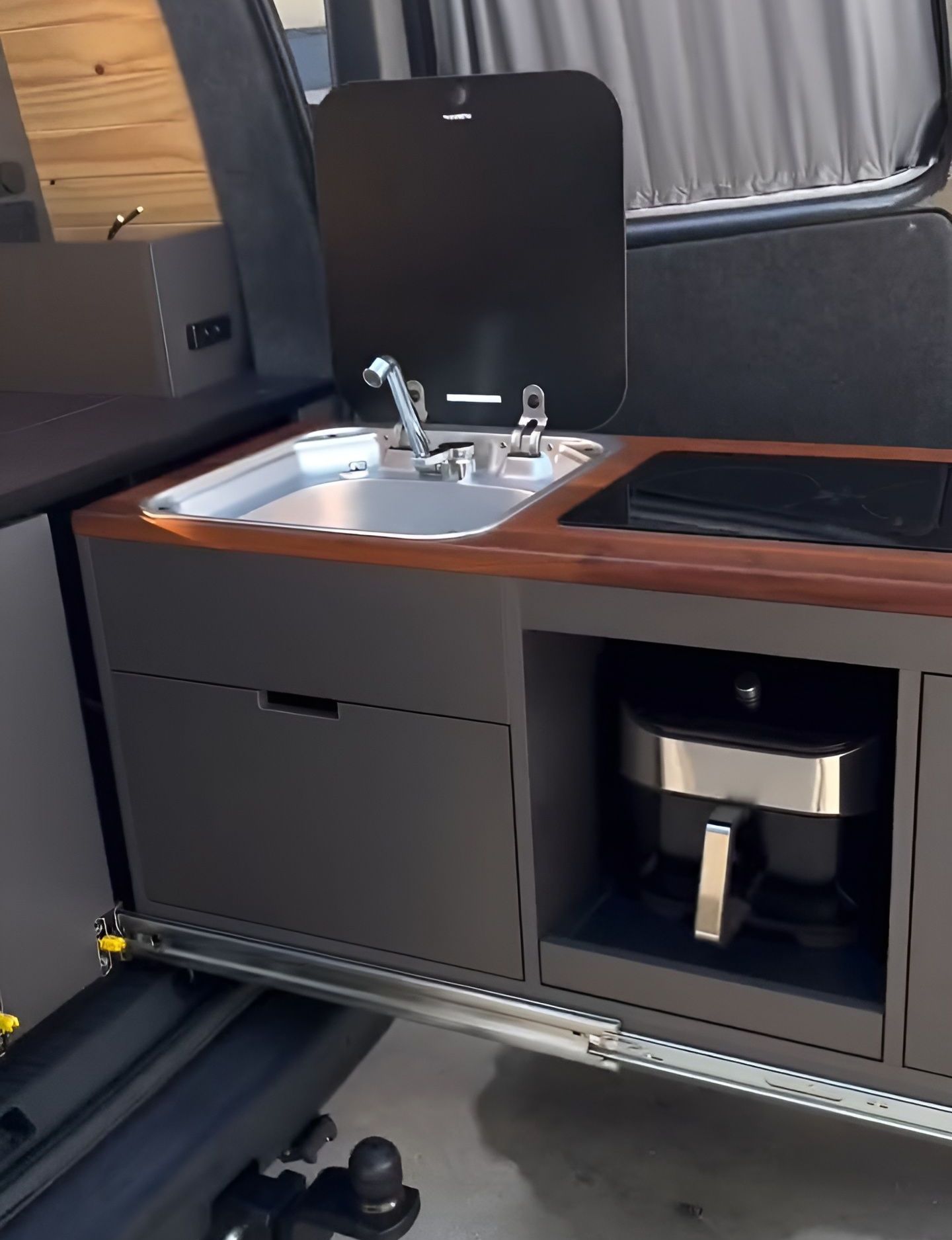 A Kitchen In A Van With A Sink And Stove — Live Unbound Campers In Brisbane, QLD