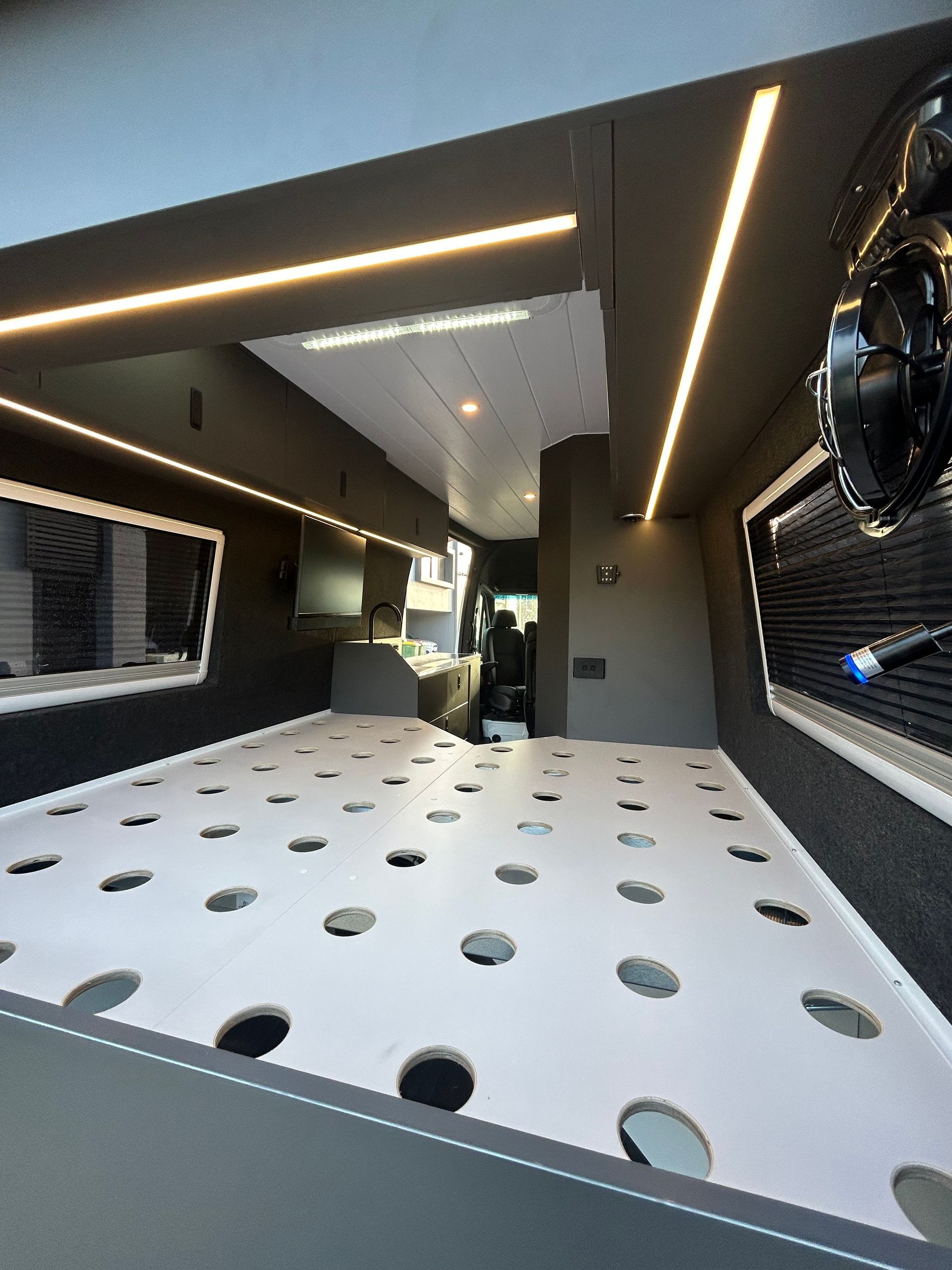 A Kitchen With A Sink, Stove, And Cutting Board — Live Unbound Campers In Upper Coomera, QLD