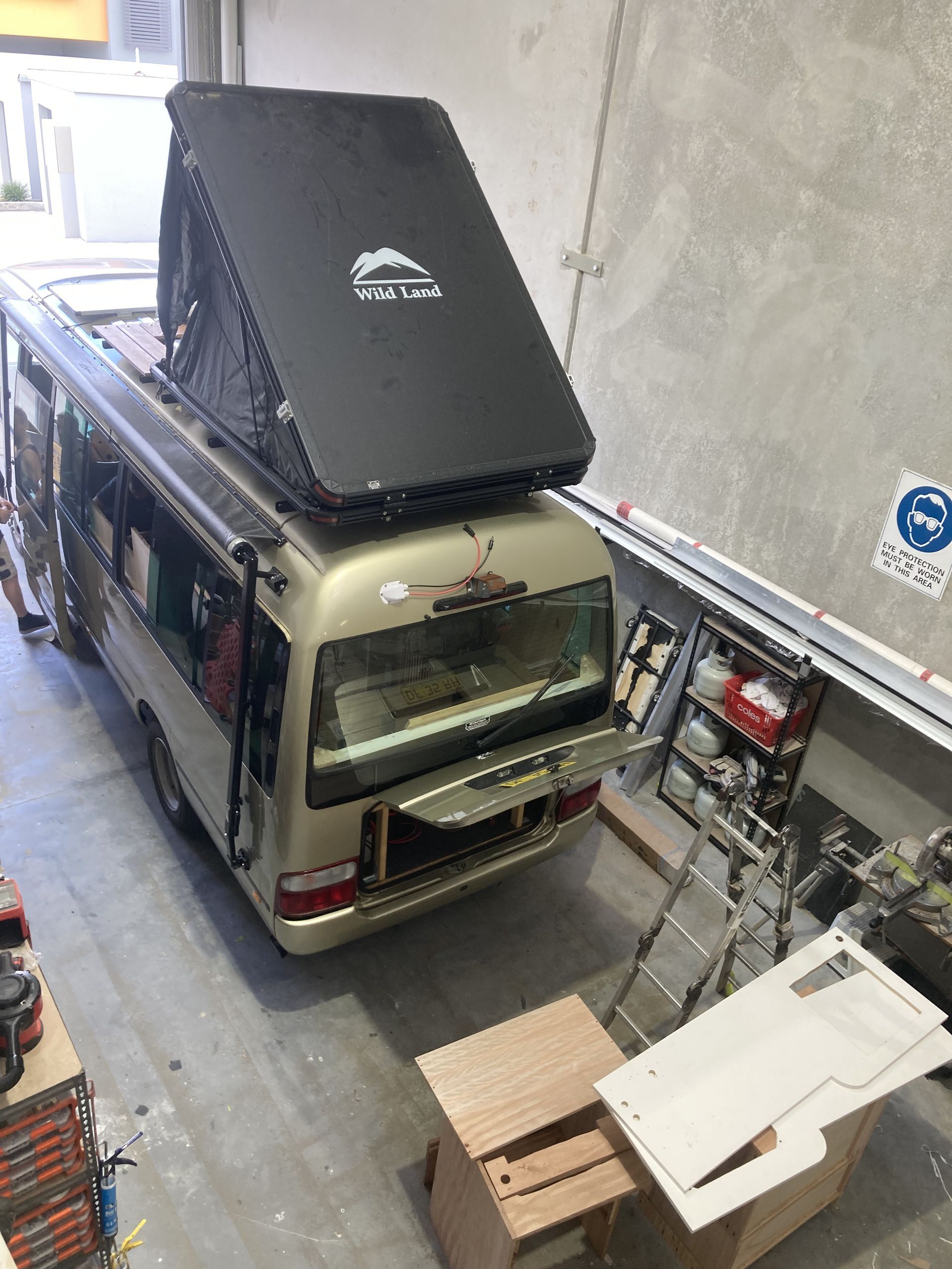 A Helmet Is Hanging On A Wooden Wall In A Van — Live Unbound Campers In Upper Coomera, QLD