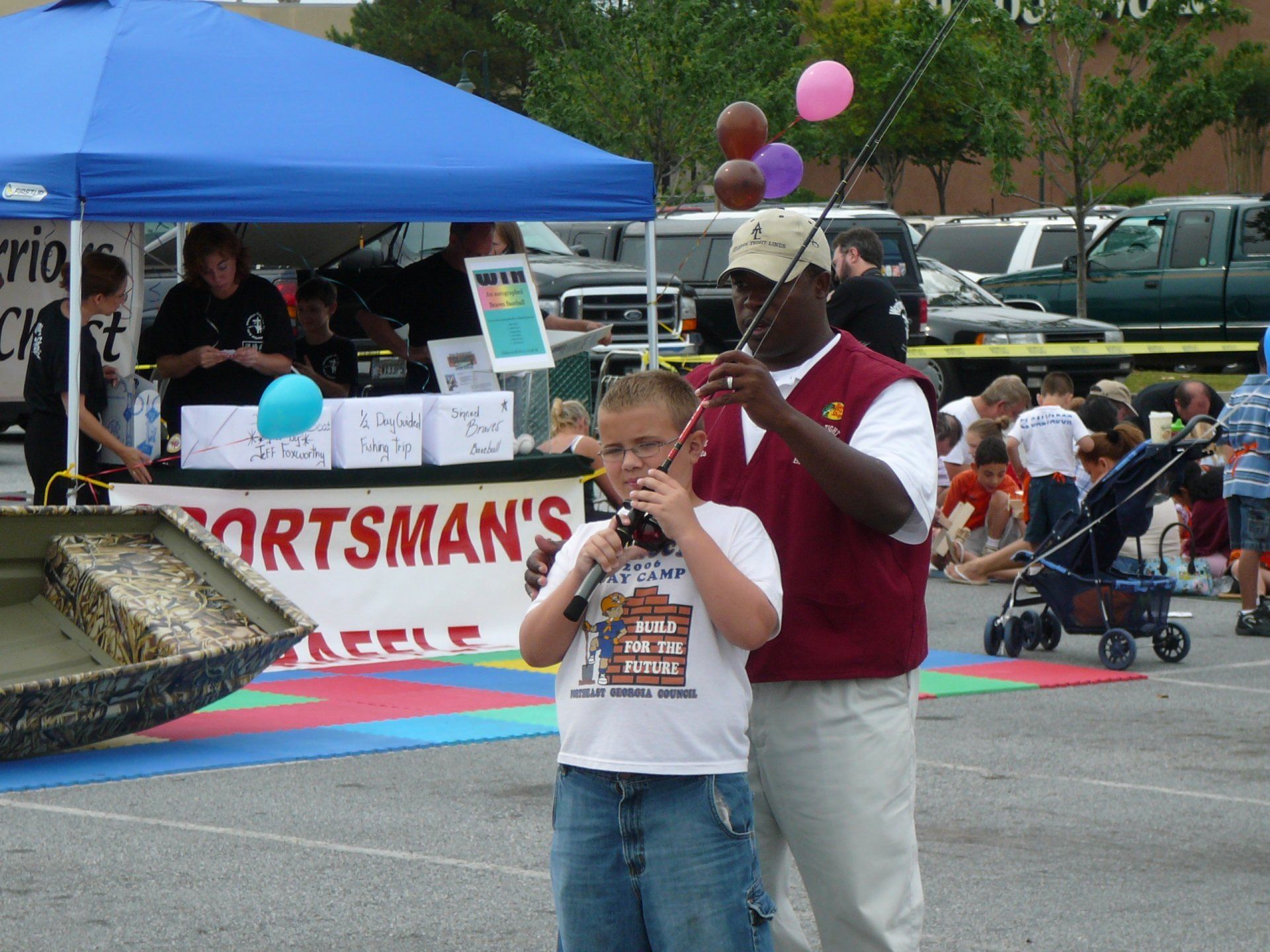 Boy with a fishing rod, helped by an adult, at a