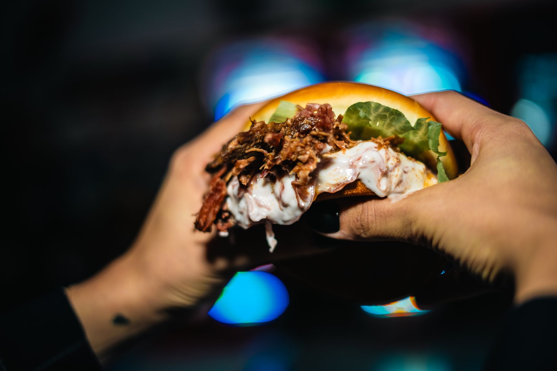 Spazio interno con sedie/tavoli rossi, un bar e TV; probabilmente un ristorante o un'area ricreativa.