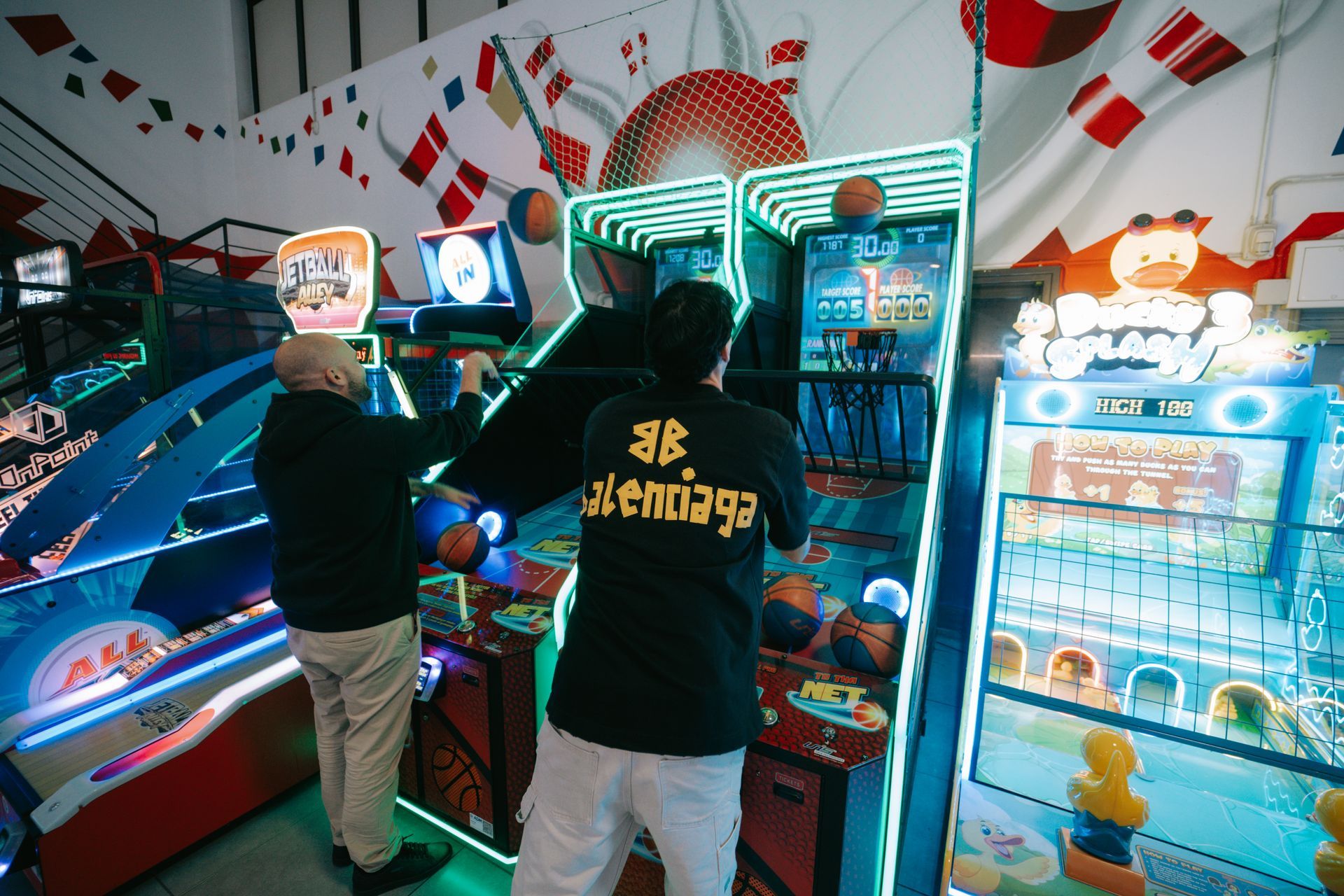 Pista da bowling al coperto con tavoli, sedie rosse e un bar.