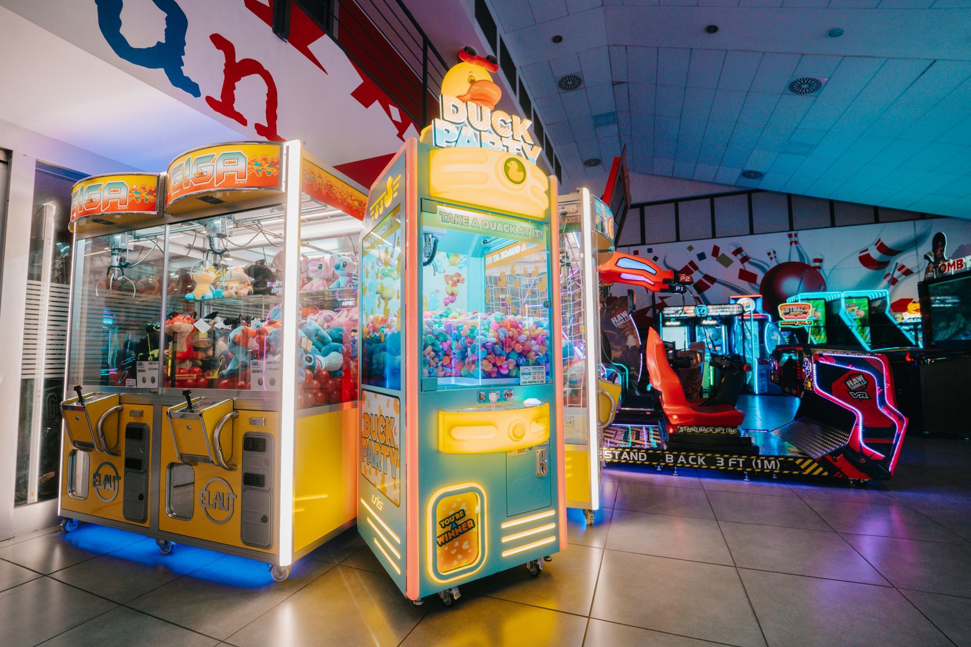 Sala giochi e pista da bowling, con un gioco a tema pirata in primo piano e piste da bowling sullo sfondo.