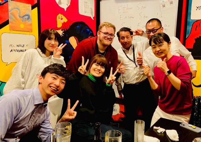 一群の人々がレストランで写真のポーズをとっています。