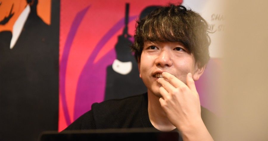 英会話レッスンで英語を話すことを考えている男性生徒