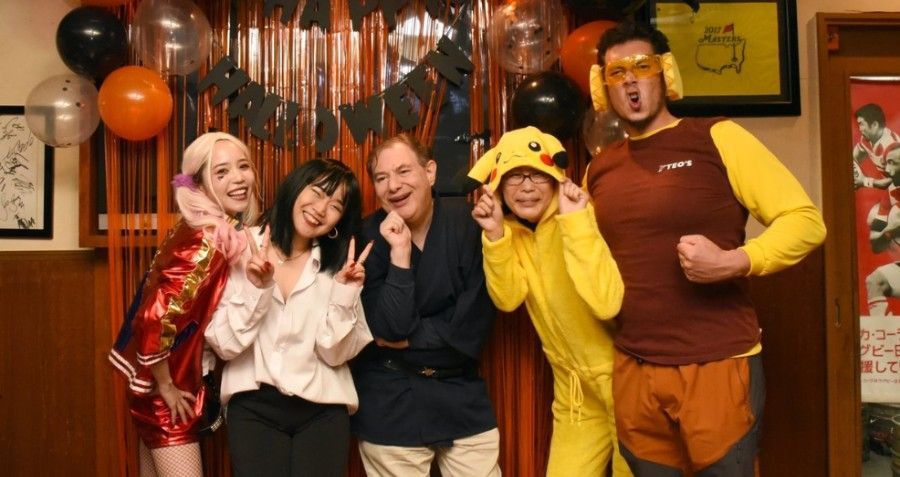 A group of people are posing for a picture at a Halloween party.