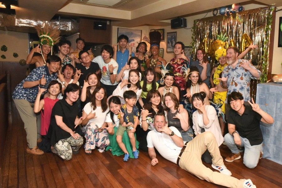 Group of international people smiling and posing in a room at Shooters Sports Bar & Grill in Nagoya.
