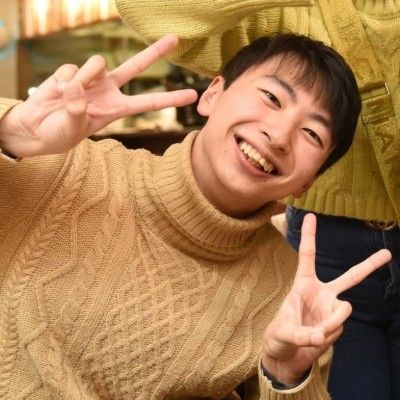 man smiling and making the peace sign with 2 fingers
