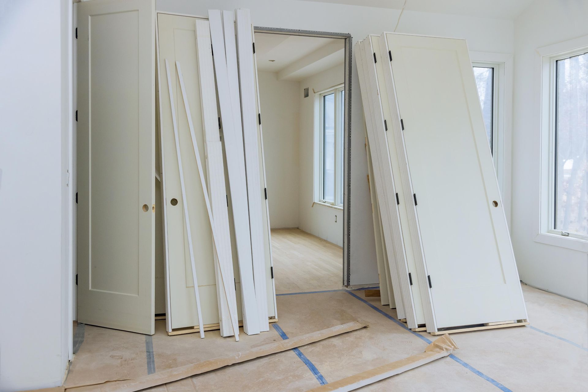Interior room with several white doors and trim, likely under renovation.