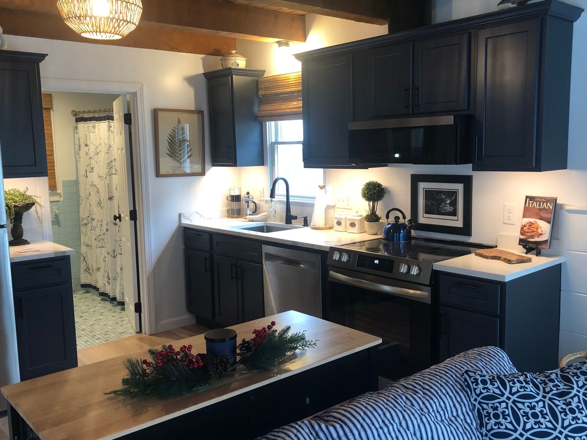 Small kitchen with dark blue cabinets, stainless steel appliances, and a light wood countertop island.