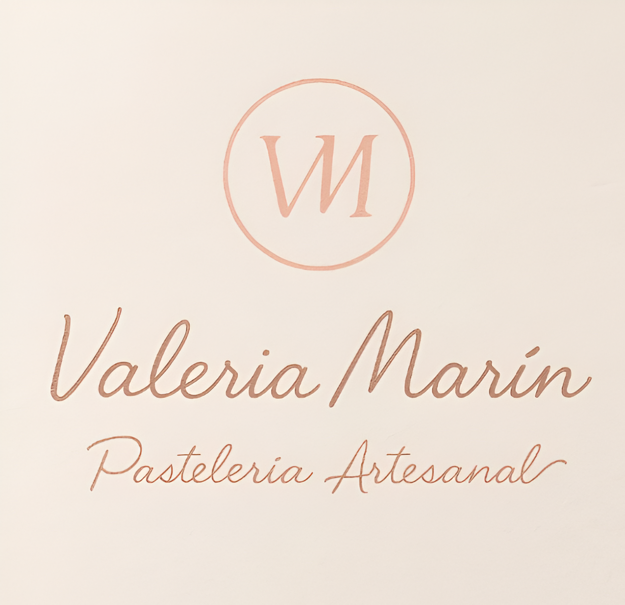 Logotipo para Valeria Marín Pastelaria Artesanal; Texto en oro rosa sobre un fondo ruborizado.