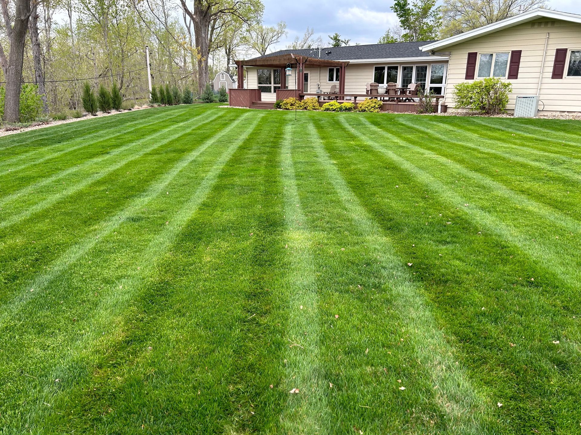 A red lawn mower is sitting in the middle of a grassy field.
