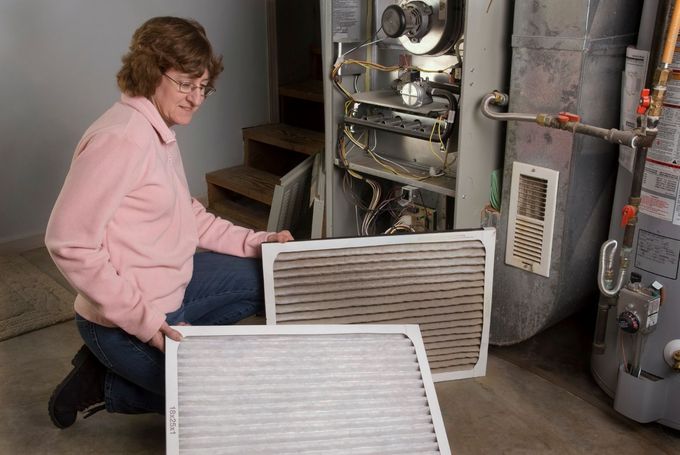 A person is pointing at a roof vent with a bunch of dust on it.