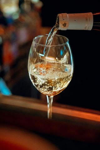 Champagne versato in un calice da vino in un bar scarsamente illuminato