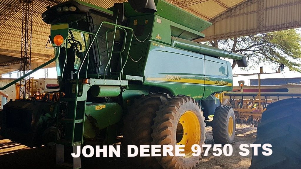 Cosechadora John Deere 9750 STS, verde y amarilla, bajo un refugio.