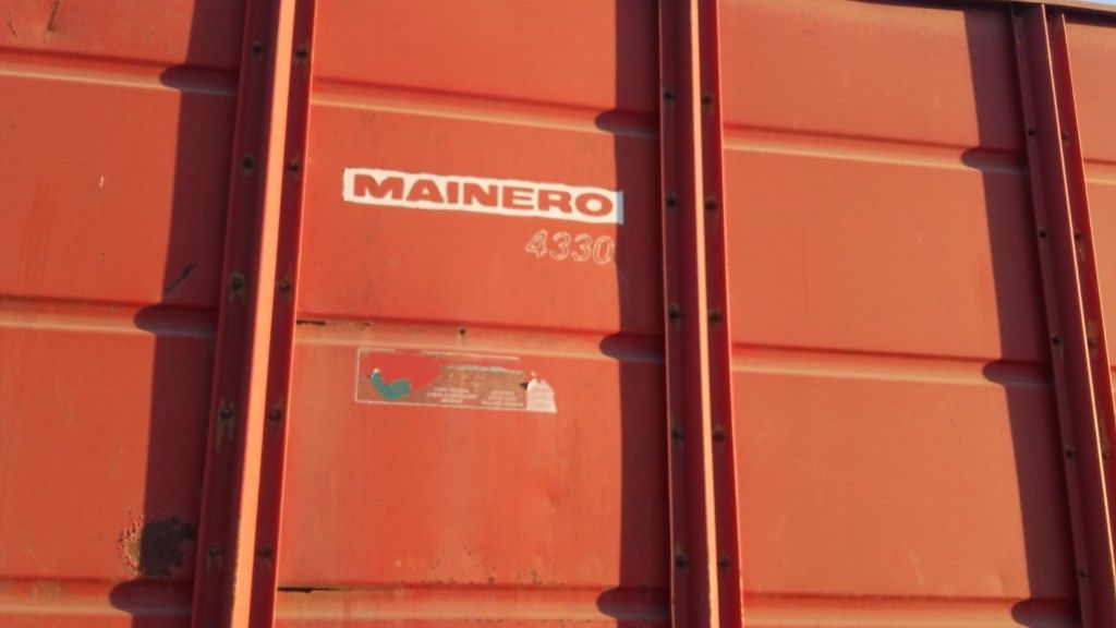 Vagón de tren de mercancías de color rojo con "MAINERO 4330" en texto blanco.