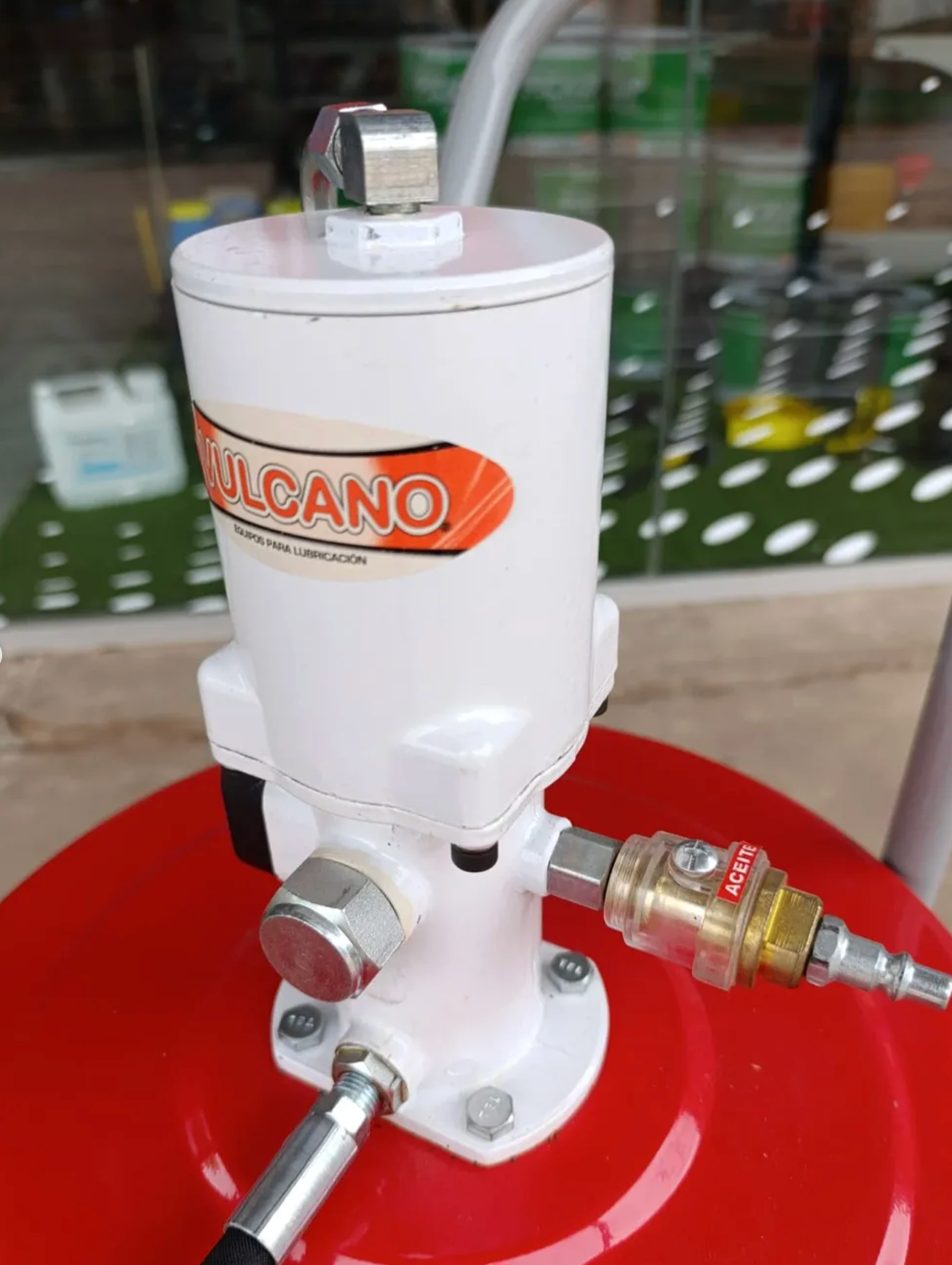 Bomba de grasa Vulcano blanca en un tanque rojo, con manguera de aire y accesorios.