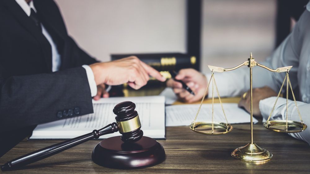 A Judge is Sitting at a Table With a Gavel and Scales of Justice — Hynes & McCormack In Murwillumbah, NSW