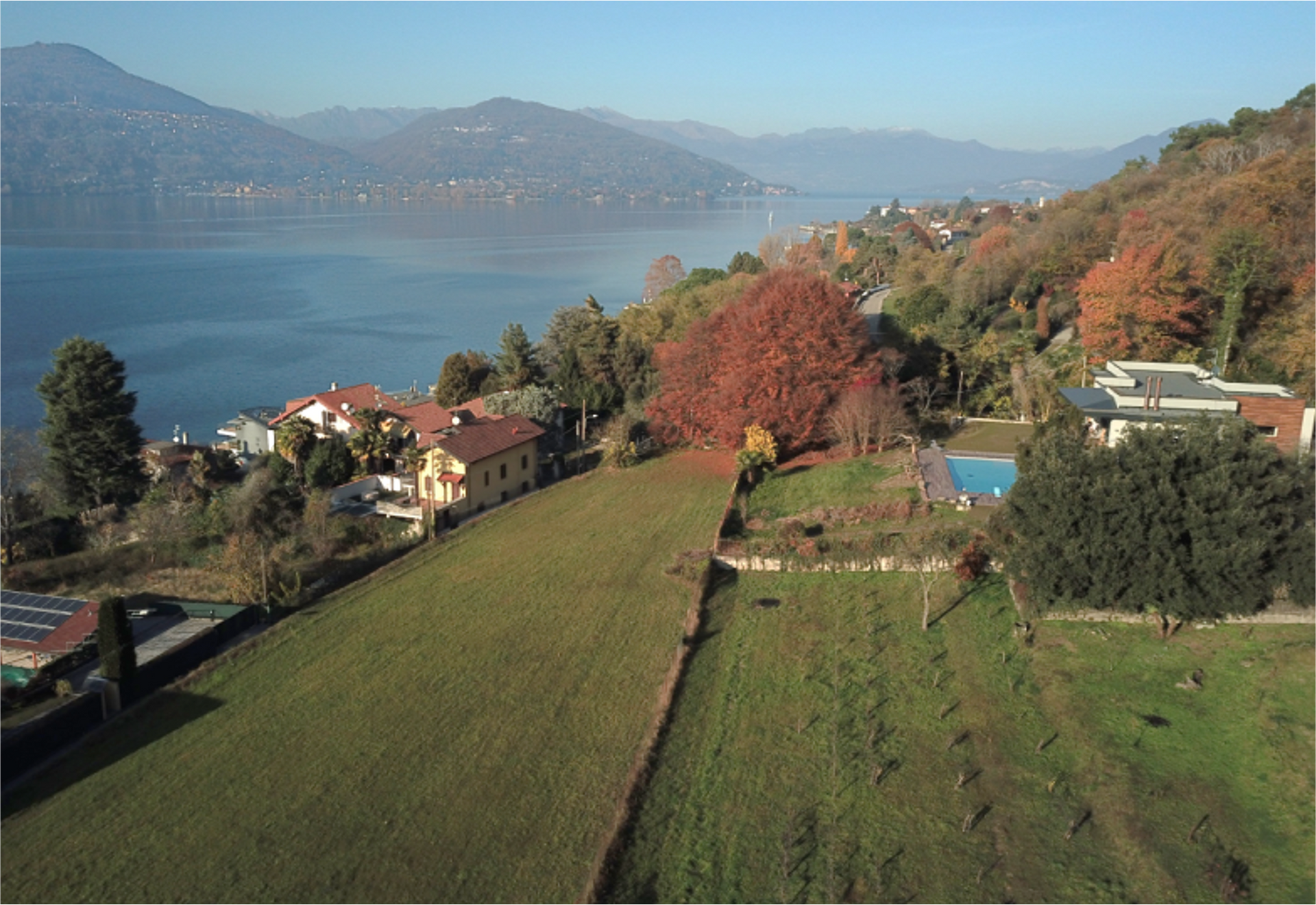 una veduta aerea di un campo con un lago sullo sfondo