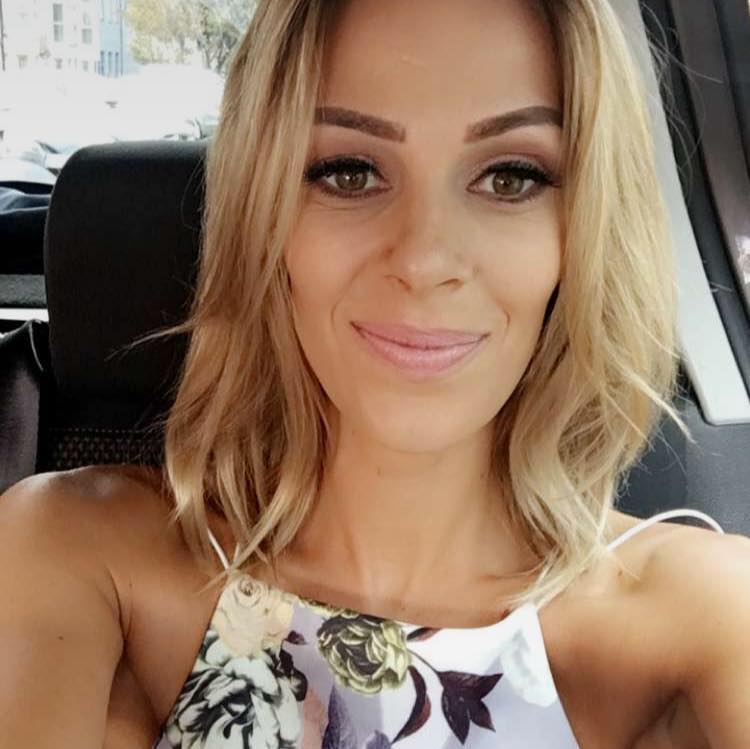 A woman is taking a selfie in the back seat of a car.