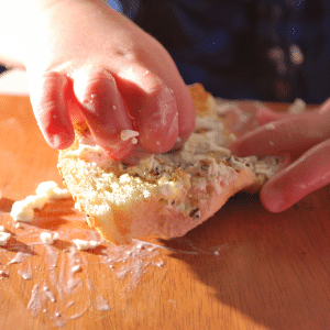 A person is spreading butter on a piece of bread