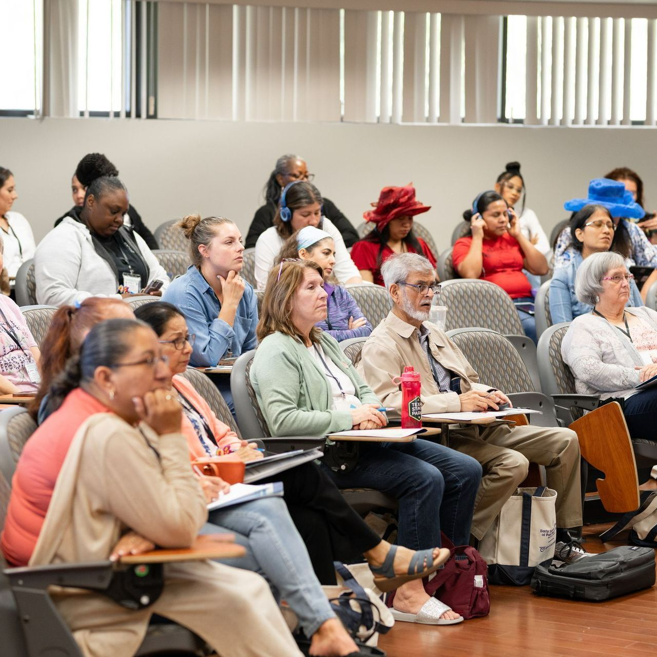 A large group of people are sitting in a lecture hall