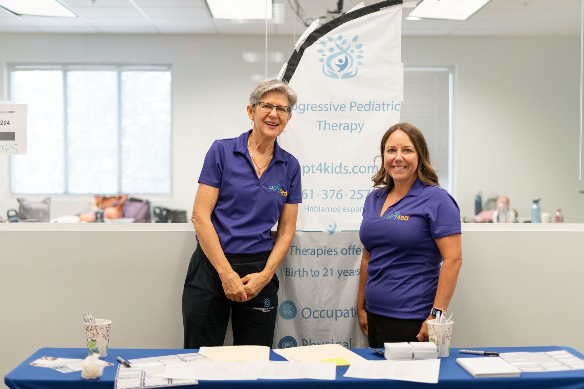 Two women at a table with a banner for 