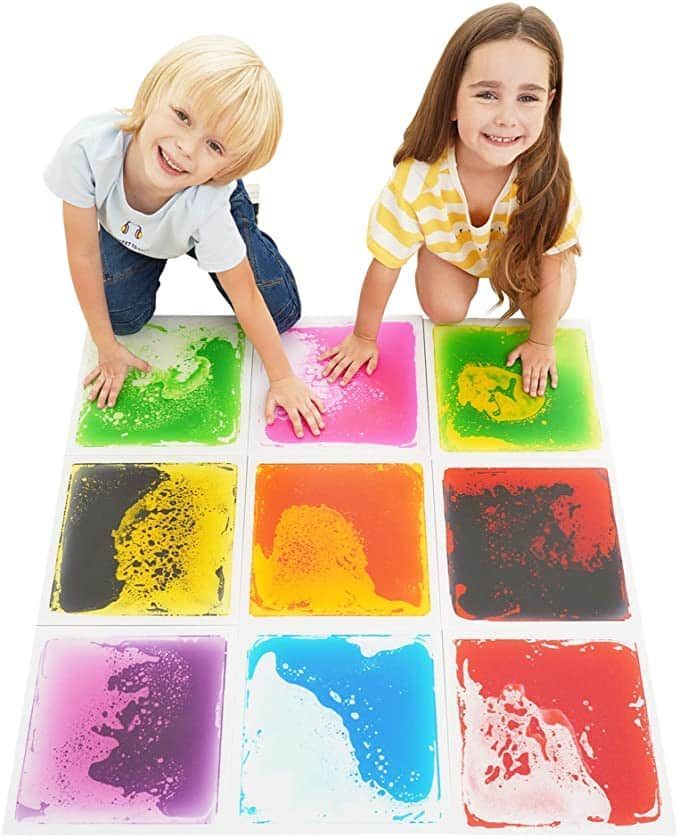 A boy and a girl are playing with liquid tiles on the floor.