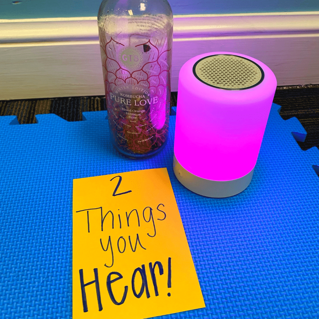 A sign that says 2 things you hear next to a bottle and a speaker