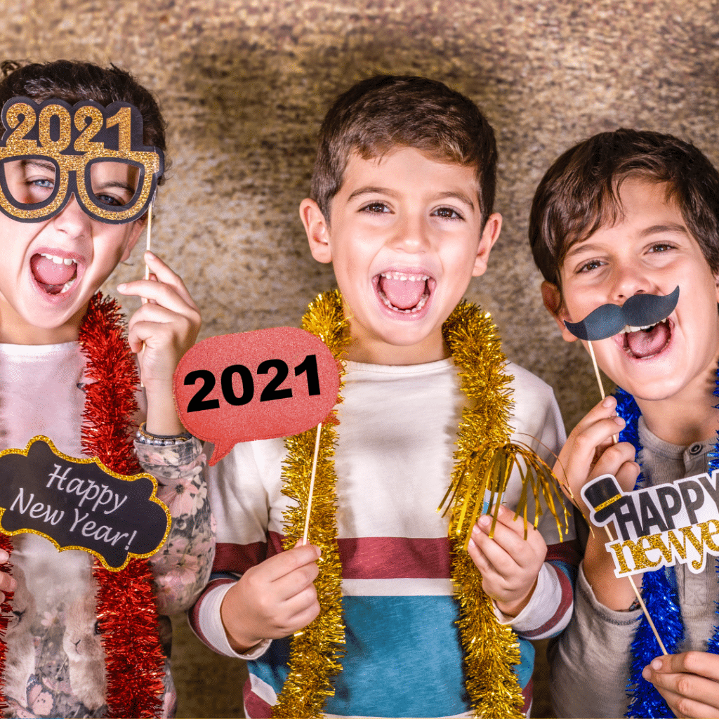 Three young boys are holding up signs that say happy new year.