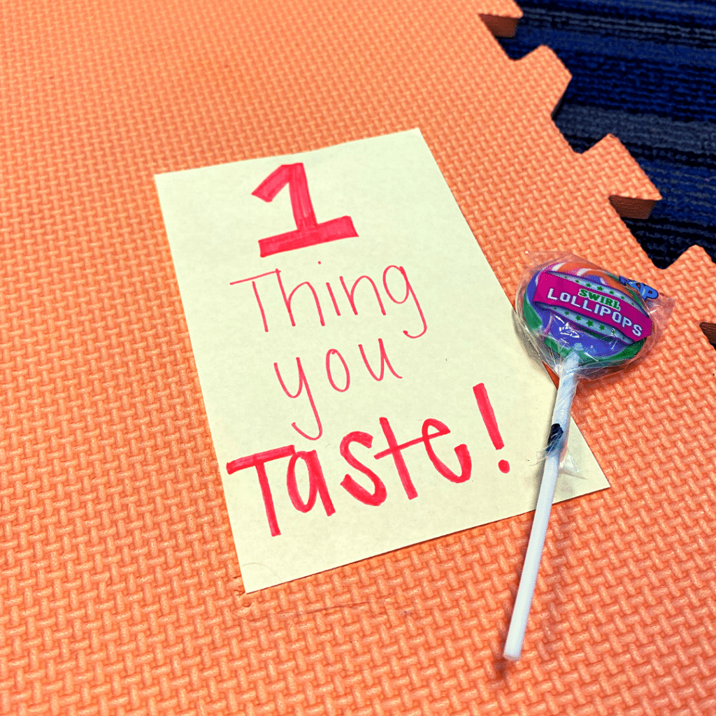 A lollipop sits next to a piece of paper that says 1 thing you taste